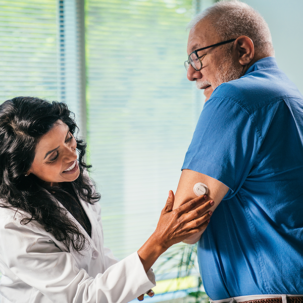 Professionnel de la santé aidant un patient à utiliser le Dexcom G7